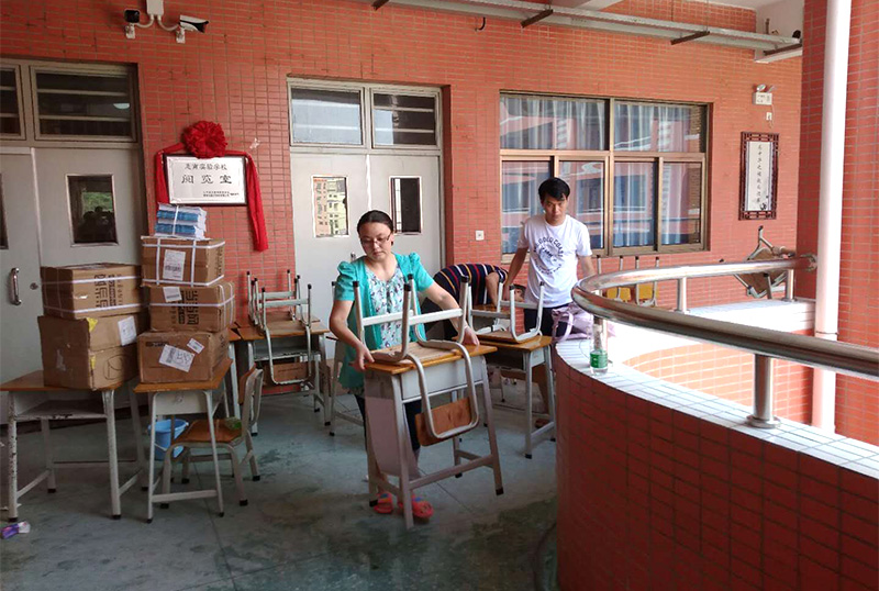 8868官方登录入口志愿者及家长用消毒液擦拭桌椅